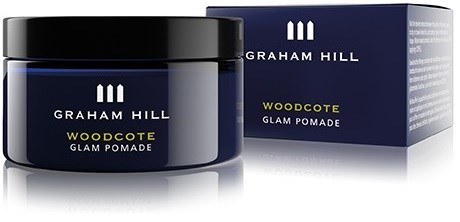 En marinblå burk med svart lock och matchande box. Etiketten säger Graham Hill Woodcote Glam Pomade.