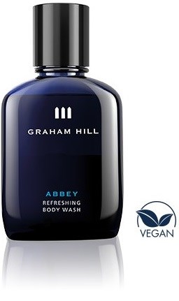 En mørk blå flaske med svart lokk, merket Graham Hill Abbey Refreshing Body Wash, og en vegansk logo.