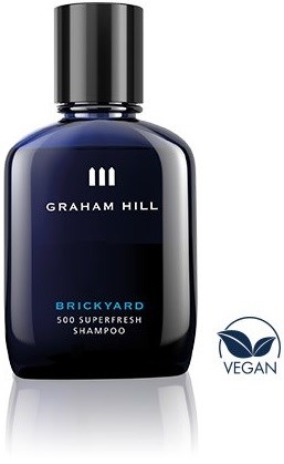 En mørkeblå flaske med Graham Hill Brickyard shampoo, sort låg og vegansymbol.