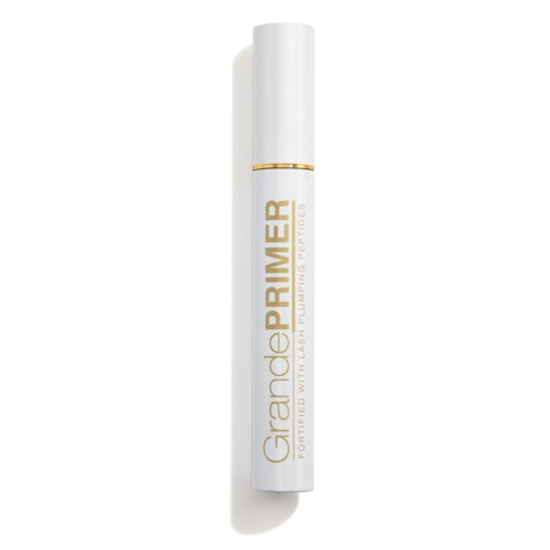 Een witte cilindervormige fles met label 'GrondePRIMER' voor gezichtsvoorbereiding, met gouden tekst en een goudband nabij de bovenkant.