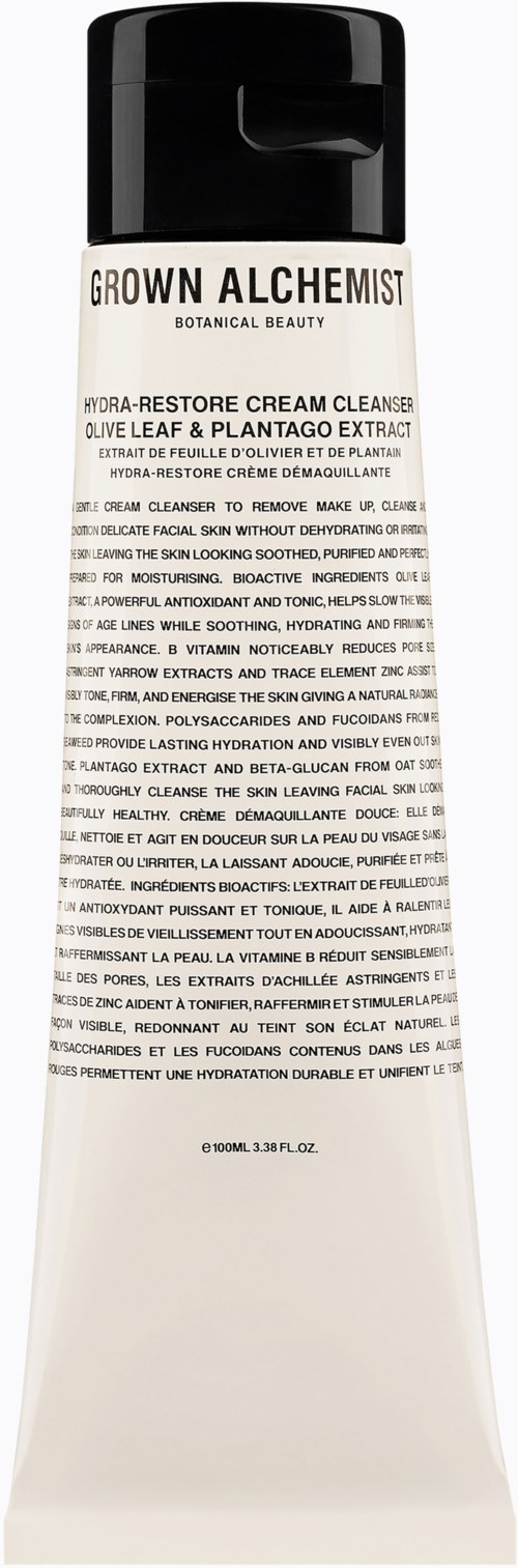 En vit tub med svart lock, märkt Grown Alchemist, botanisk skönhetsprodukt med text som beskriver ingredienser och användning.