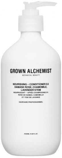 En vit flaska med Grown Alchemist-balsam med pump, innehållande botaniska ingredienser som damaskros och kamomill.
