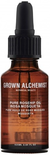 En liten bärnstensfärgad glasflaska med svart pipettlock, märkt 'GROWN ALCHEMIST' och 'PURE ROSEHIP OIL'.