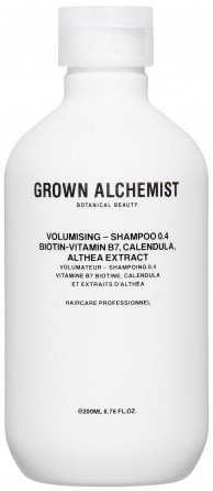 En vit schampoflaska med svart text, märkt Grown Alchemist, med växtbaserade ingredienser och professionell användning.