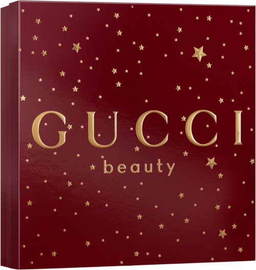 Red box with gold stars and the words 'GUCCI beauty' in gold letters. Elegant and festive design.