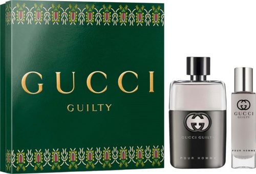 Gucci Guilty parfumsset met een grote groene doos en twee flessen, een helder en een wit, met zwarte en zilveren doppen.