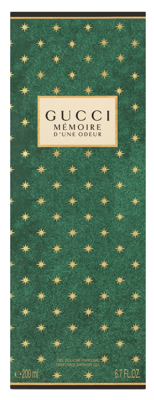 En grön rektangulär box dekorerad med gula stjärnor, med texten 'GUCCI Mémoire d'une Odeur' i mitten.