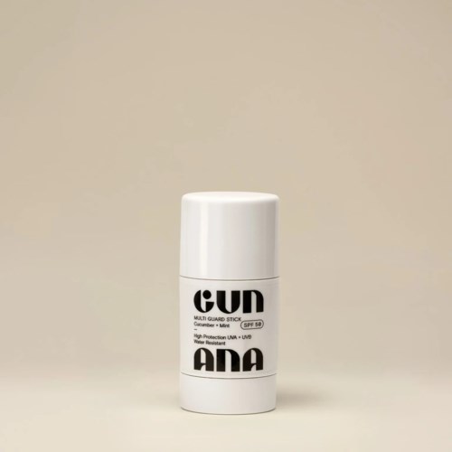 Ein weißer Stiftbehälter mit schwarzem Text, als Sonnenschutzspray mit SPF 50 gekennzeichnet. Minimalistisches Design.