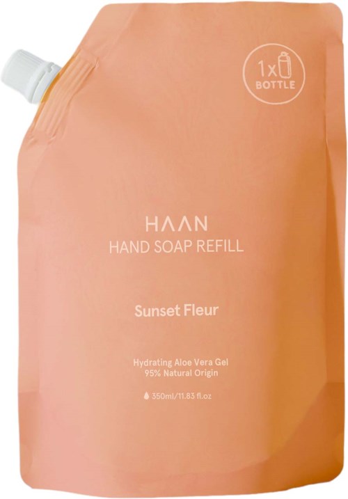 A peach-colored refill pouch for hand soap with a white cap on the top left, labeled "Haan Hand Soap Refill" and "Sunset Fleur."