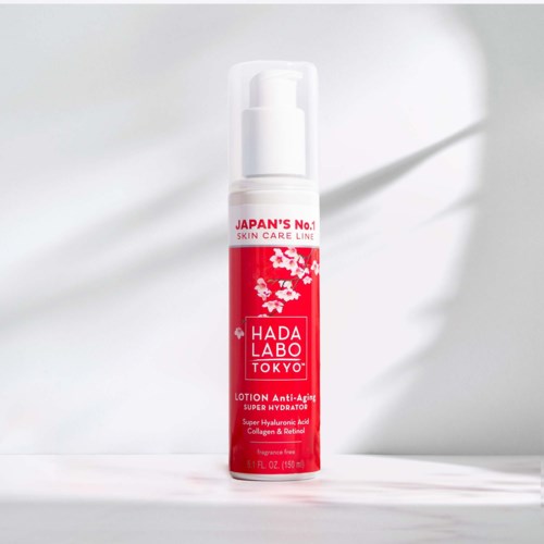 En rød og hvit flaske av Hada Labo Tokyo anti-aldringslotion med kirsebærblomstdesign på etiketten.