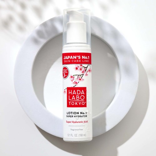 En hvit lotionflaske med rødt og rosa design, merket som Hada Labo Super Hydrator med hyaluronsyre.