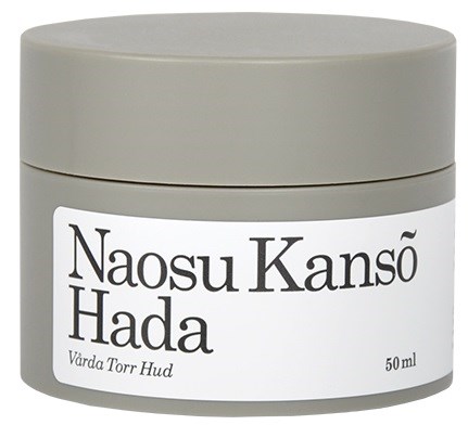 En liten, rund, grå behållare med vit etikett. Den har text och troligen innehåller hudvårdskräm.