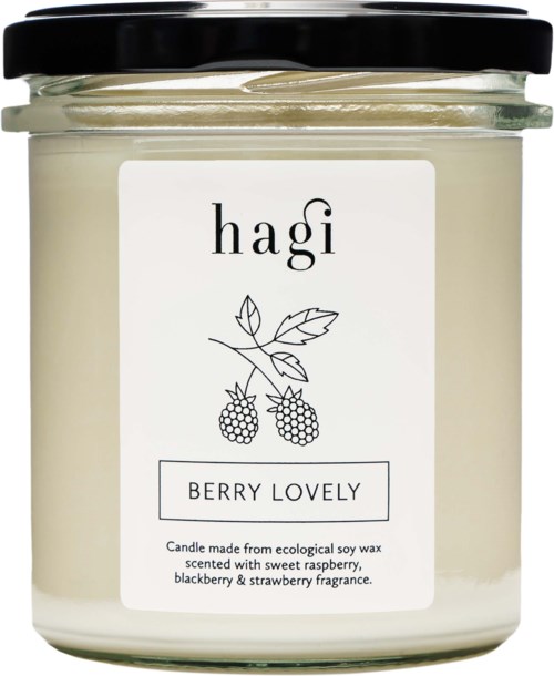 Ett vitt ljus i glasburk med svart lock, märkt 'hagi Berry Lovely' och en bärillustration.