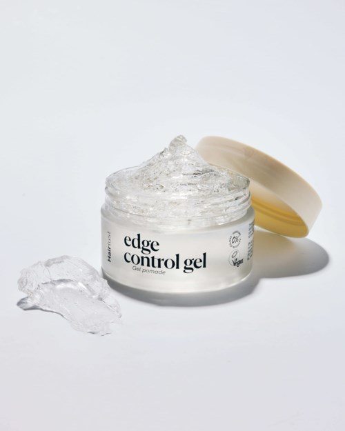 Geopende pot met edge control gel met wat gel ernaast. De pot heeft een witte sticker en een beige deksel.