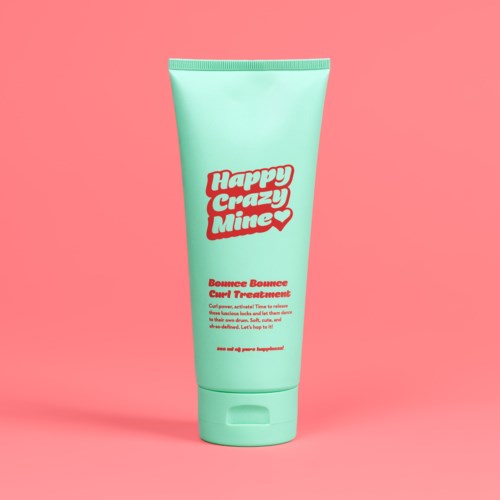 Een mintgroene tube met ‘Happy Crazy Mine’ in rode tekst, op een roze achtergrond.