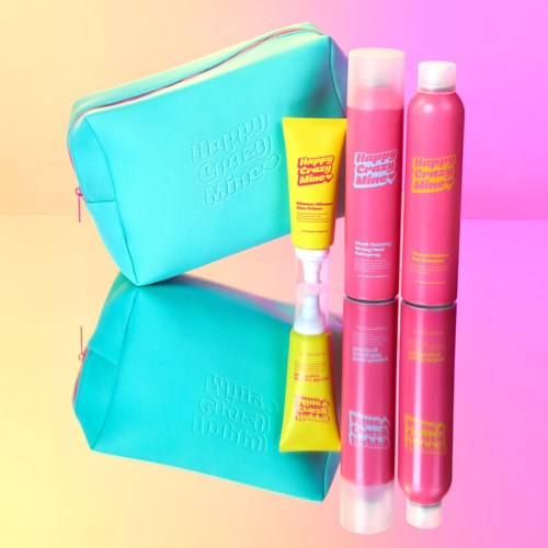 Lyseblå taske med pink, gul og pink flasker og en gul tube, alle med "Happy Creatures Mine" etiketter.