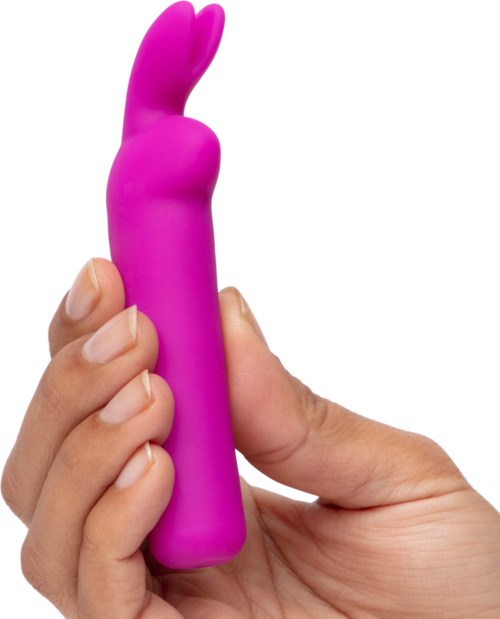 Een hand houdt een roze, konijnvormige massager of vibrator.