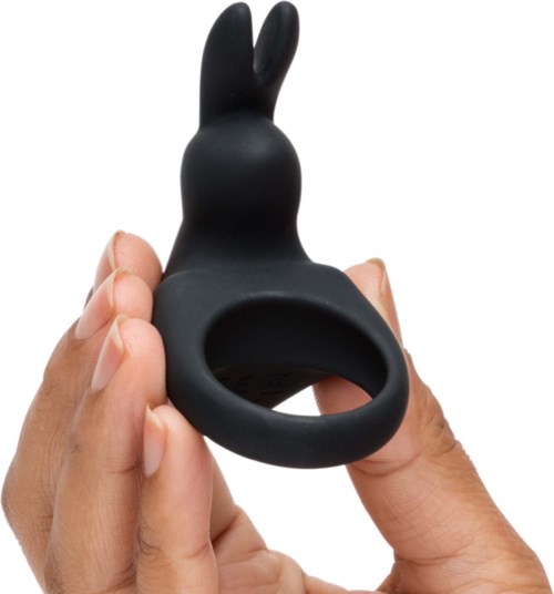 En svart, kaninformad silikonföremål med en ring längst ner, hålls av en persons hand.