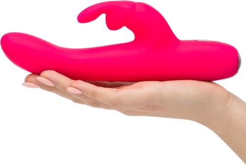 Een hand houdt een groot roze siliconenvoorwerp in walvishouden. Het is glad en gebogen.