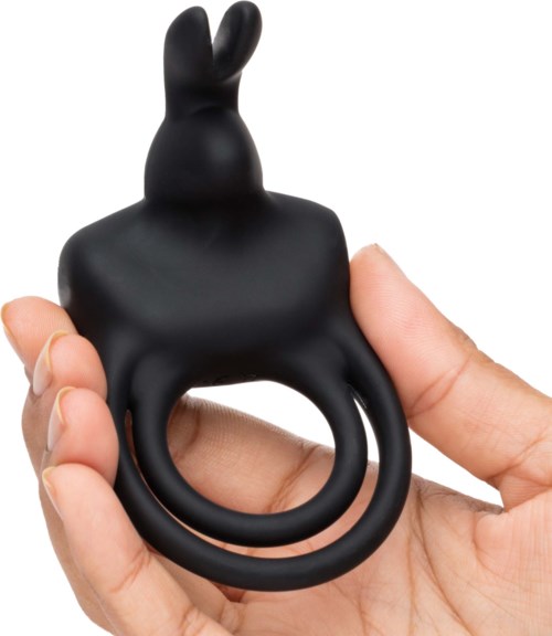 Een zwart konijnvormig voorwerp met een ring onderaan, vastgehouden door een hand.
