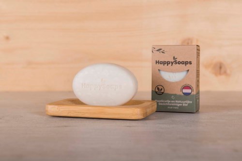 Saippura ja 'HappySoaps' -merkitty saippapaketti puuastiassa.