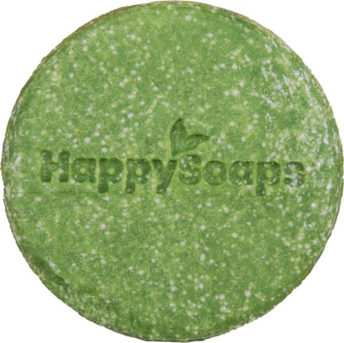En rund grön tablett med texten 'HappyCaps' och en liten bladlogga präglad på den.