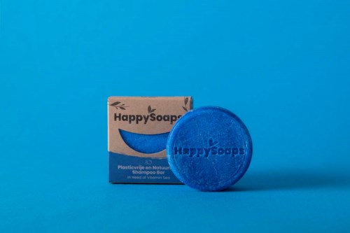 Sininen shampoopala ja sen laatikko sinisellä taustalla. Merkkini on HappySoaps.