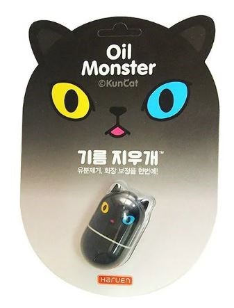 Mustamainen kissa-muotoinen öljymonsteripakkaus, jossa on pieni öljyastia. Merkkinimi Haruen.