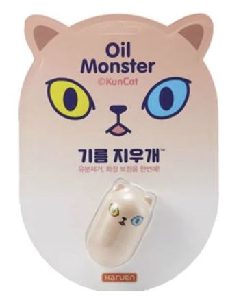A cat-shaped oil remover tool with one yellow eye and one blue eye, labeled 'Oil Monster' and small Japanese text.