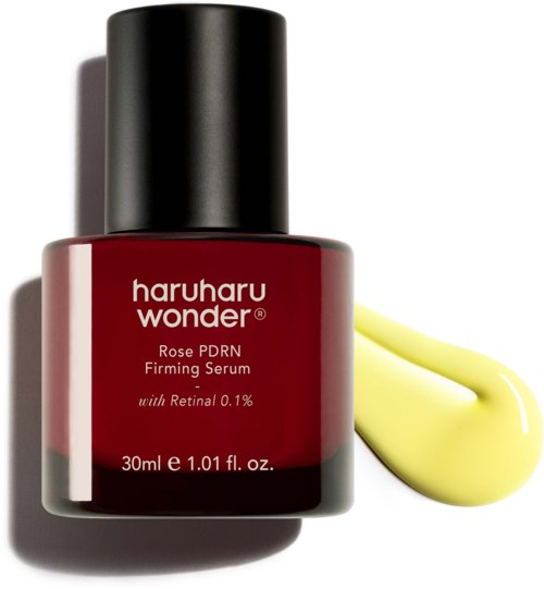 Eine rote Flasche Haruharu Wonder Rose PDRN Ferming Serum mit einem gelben Klecks daneben.