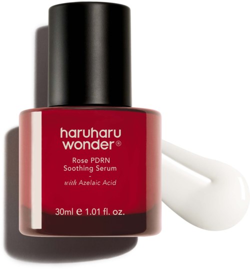 Eine rote Flasche Haruharu Wonder Rose PDRN Beruhigungssirup mit einer weißen Serum-Tropfen daneben.