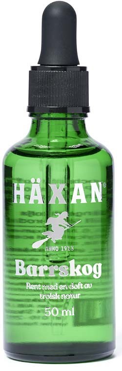 Grön glasflaska med dropplock samt etikett med texten 'Häxan Barrskog' och en häxsilhuett, 50 ml.