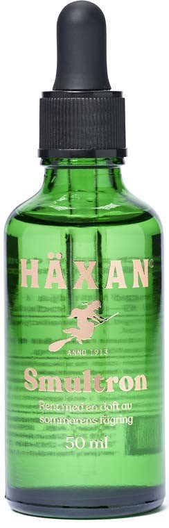 Grön flaska med pipett, märkt Häxan Smultron, innehåller vätska för hud eller hälsa.