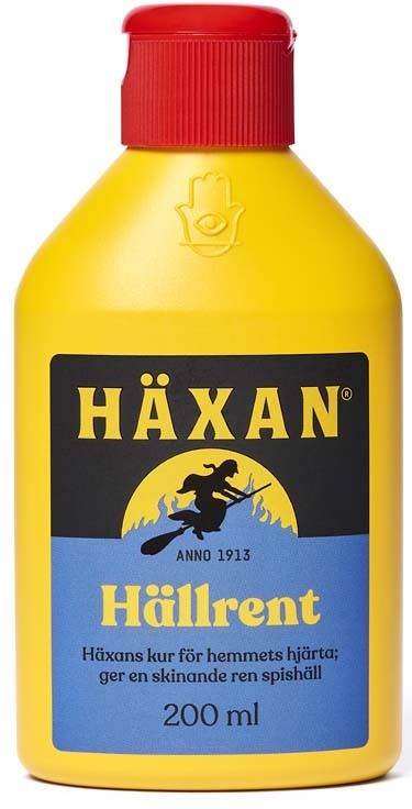 En gul flaska med röd cap, märkt 'HÄXAN Hällrent' i svart och blått, med en häxillustration.