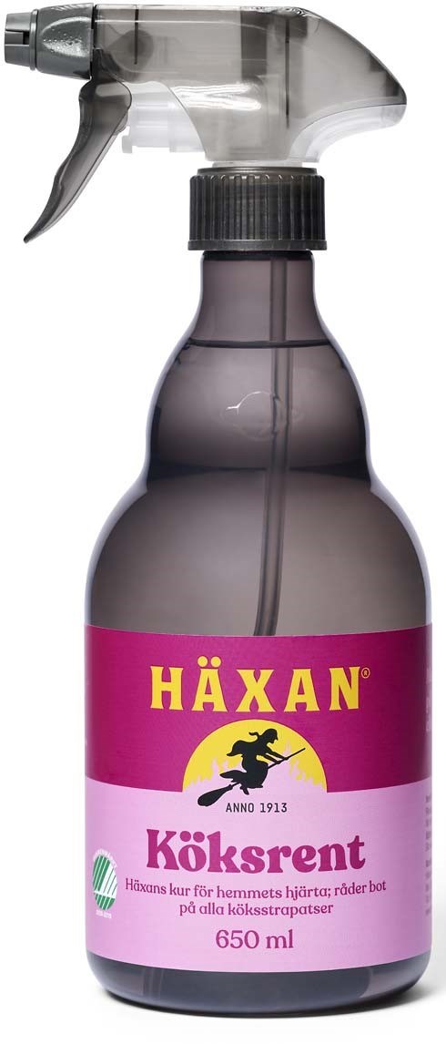 En mörkgrå sprayflaska med svart trigger och en rosa etikett med texten "Häxan Köksrent" på svenska.