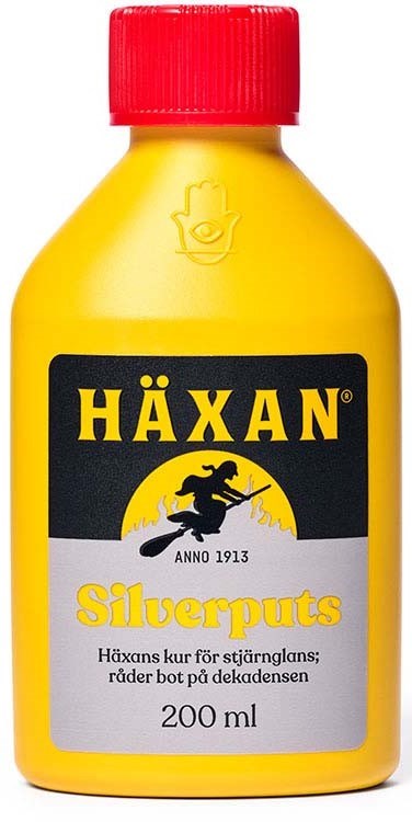 Gul flaska med röd kork, etikett säger HÄXAN Silverpups, 200 ml, med en svart och gul logga av en häxa.