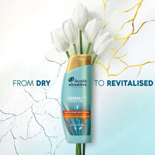 En sjampo-flaske med hvite tulipaner og blå bakgrunn, med teksten 'From Dry to Revitalised'.