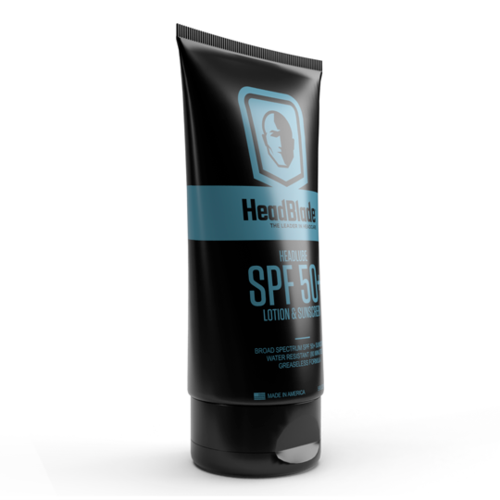 En sort tube mærket 'Head & Blonde' med SPF 50 til solbeskyttelse, med blå bånd og en logo af et ansigt.