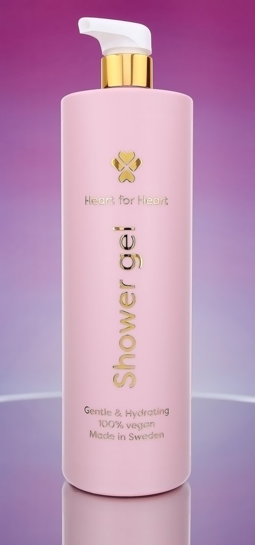 En rosa flaske med dusjsåpe med hvit pumpe, gulldetaljer og teksten "Heart for Heart" og "shower gel."