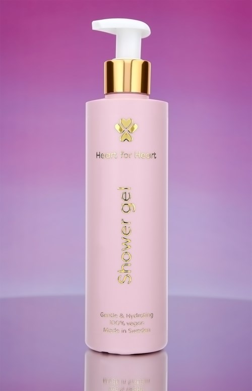 En rosa flaske med pump, gulltop, og teksten "Shower gel" og "Heart for Heart" på.