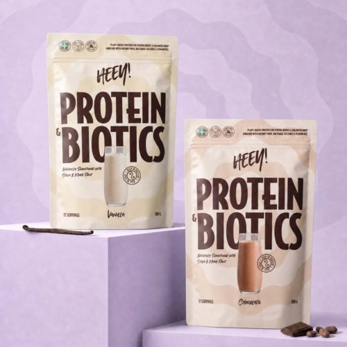 Zwei Protein- und Biotikspackungen, Vanille und Schokolade, stehen auf violetten und rosa Podesten.