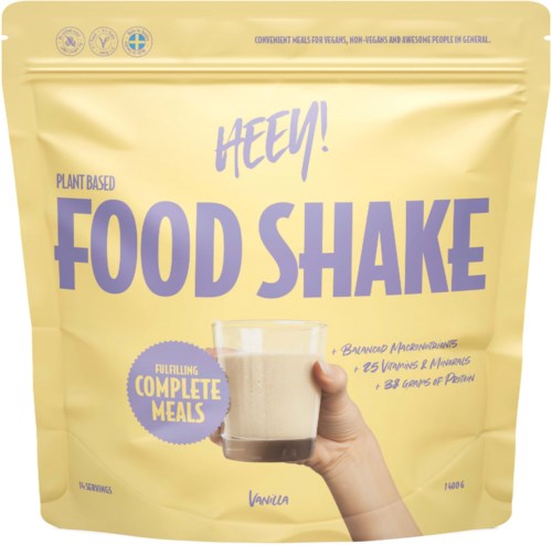 A plant-based food shake in a yellow pouch with purple text, showing a glass of vanilla flavor. It highlights complete meals.