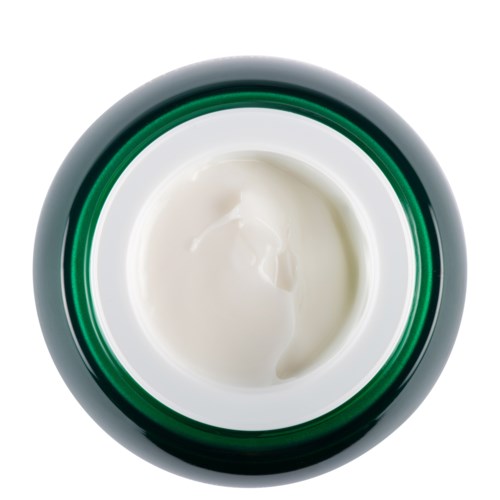 Ett öppnat burk med vit kräm eller lotion med ett silver- och grönt lock.