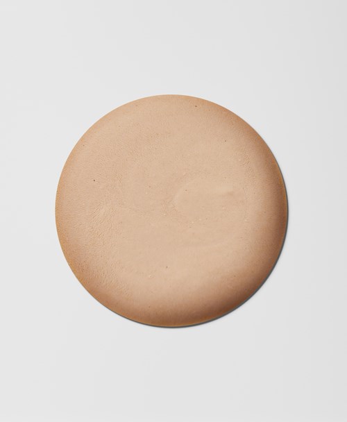 A round, beige, smooth disc on a white background.