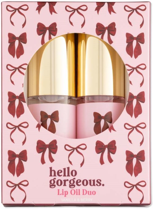 Two lip oil bottles with pink and gold caps in a pink box decorated with brown bows.