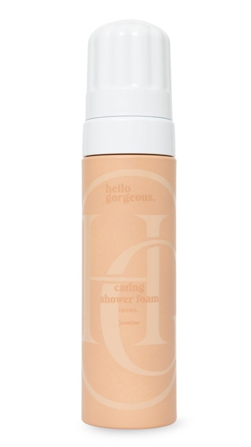 Beige, zylindrische Flasche mit weißem Deckel, beschriftet 'caring shower foam'.