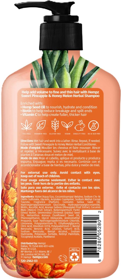 A peach-colored shampoo bottle with green leaves and pineapple illustrations, orange label with text and barcode.