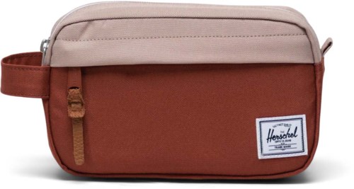 A small, rectangular bag with beige and brown colors, zipper pocket, and Herschel logo label.