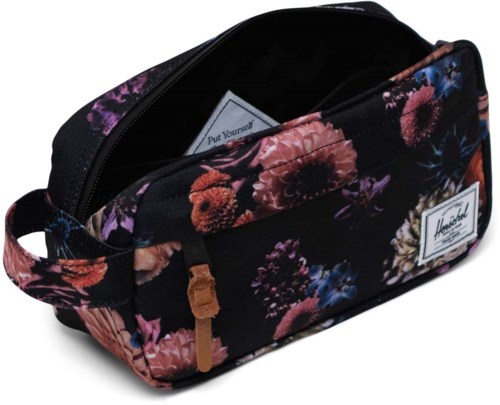A floral-patterned bag with a zipper, partially open, showing a white card inside. It has a handle on the side.