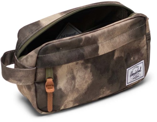 A brown, camo-patterned fabric bag with a zipper and a front pocket, brand label on the front.